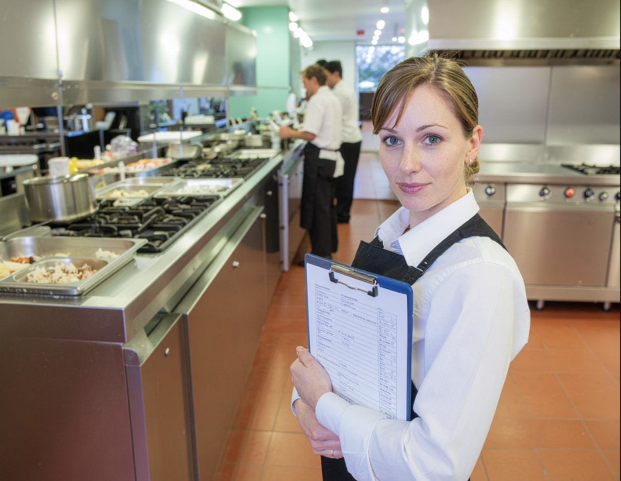 A manager walking the line with a signed, dated line-walk sheet on a clipboard